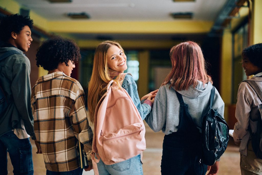 Happy,Teenager,Girl,With,Her,Classmates,Walking,Through,High,School