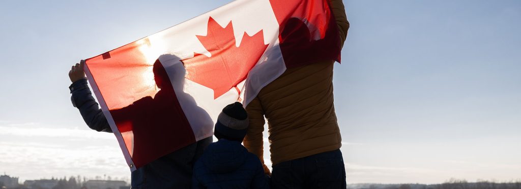 The,Family,Holds,The,Canadian,Flag,Behind,Their,Backs,Against